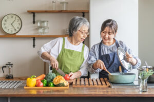 高齢の母と娘　台所　キッチン　料理　クッキング